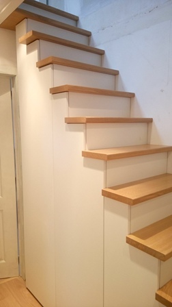 Escalier sur mesure avec marches en chêne et placard intégré en mélaminé blanc